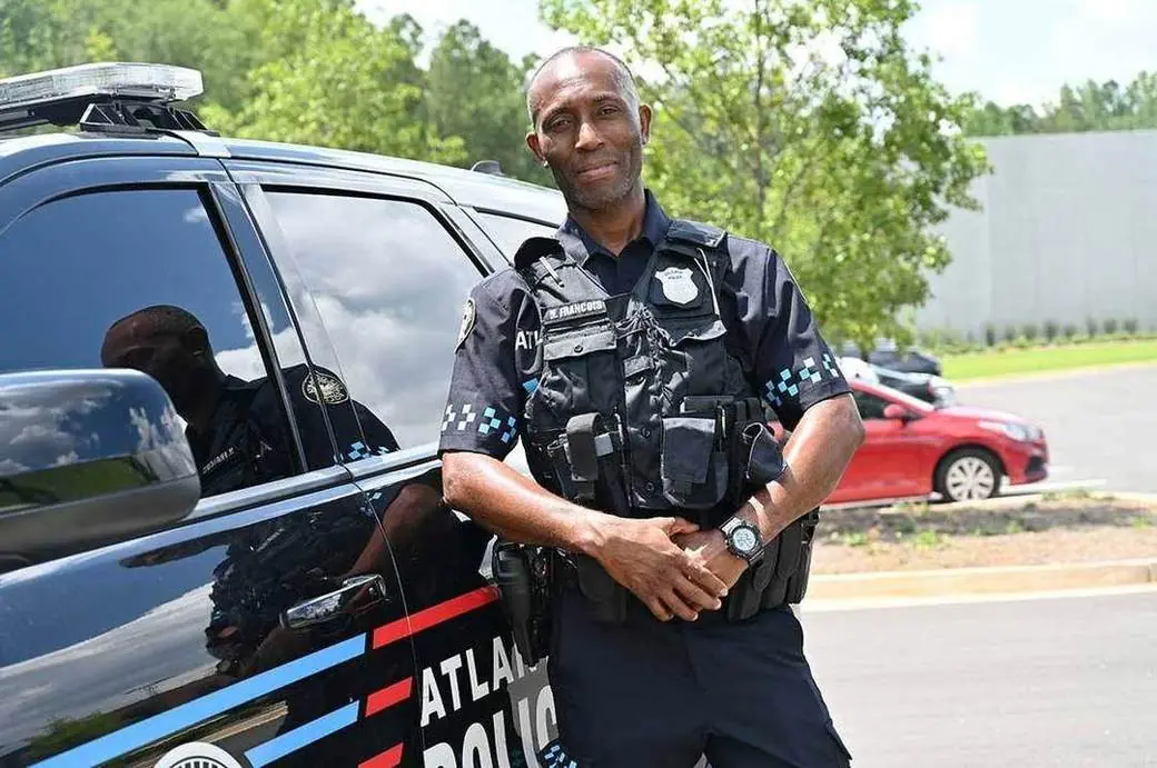 An Atlanta Police officer beside a patrol vehicle