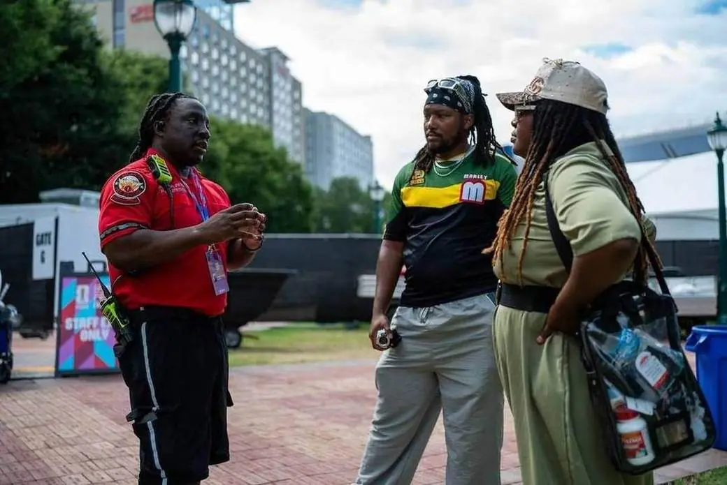 An Atlanta Fire Rescue staffer assists visitors at the Fan Festival