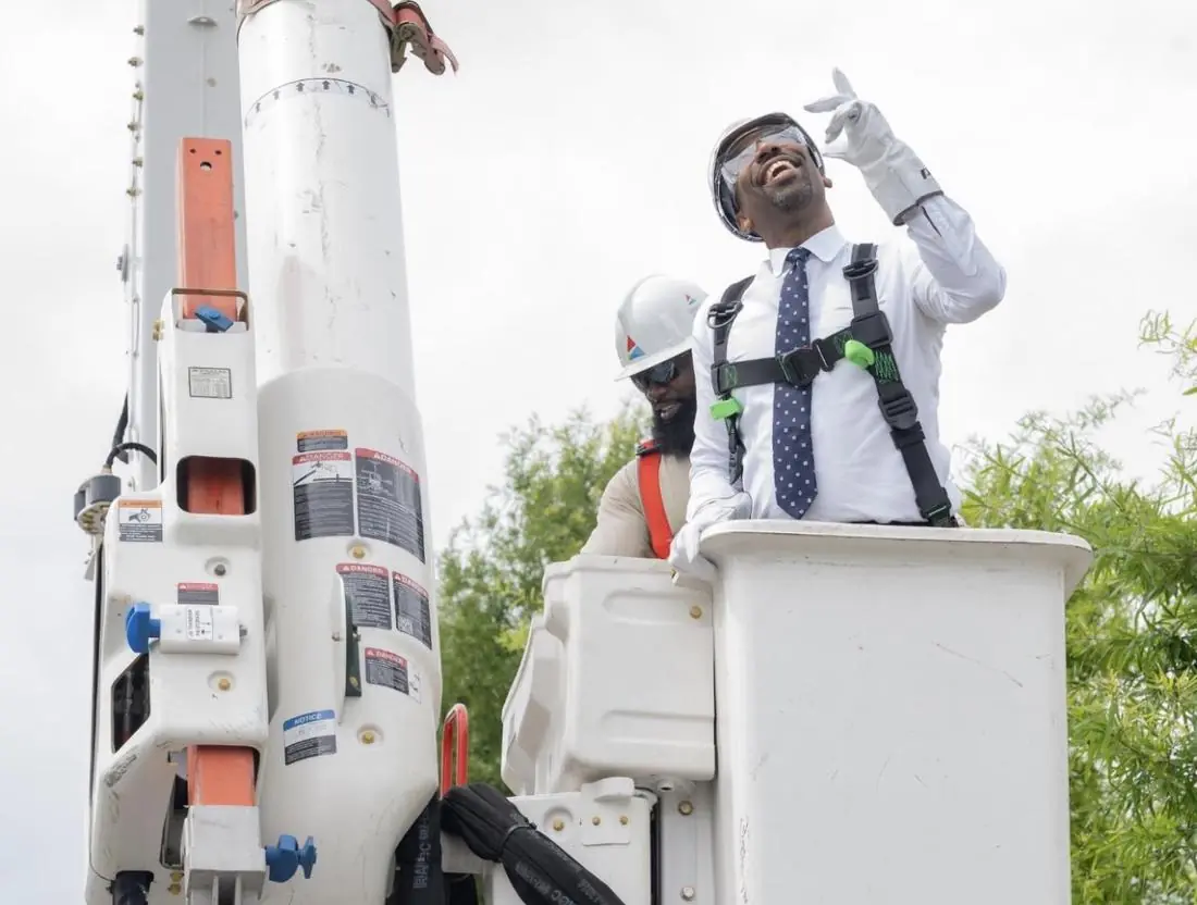 Mayor and a utility worker inspecting a new streetlight from a bucket truck