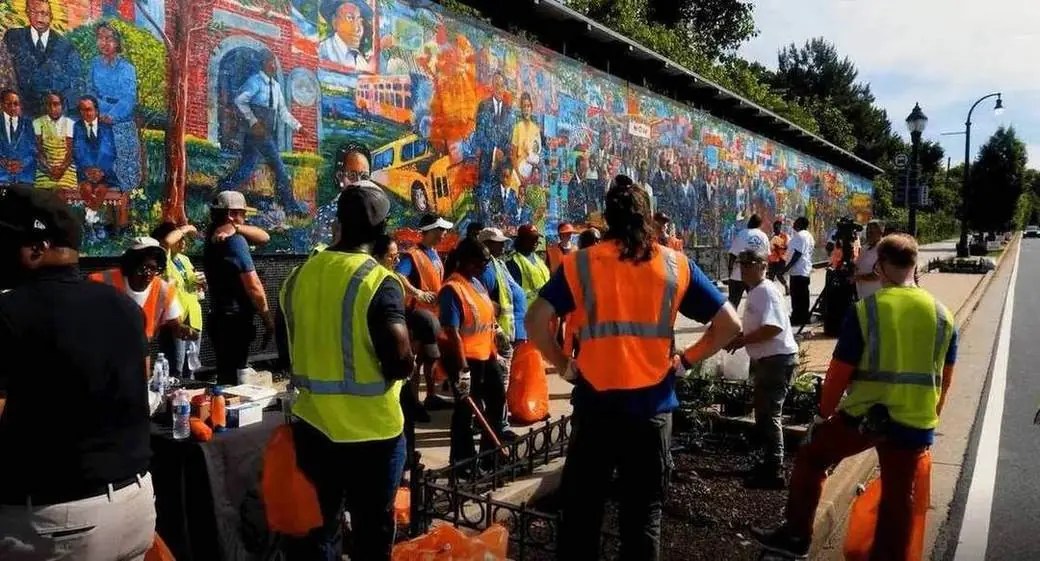Public Works crews in safety vests cleaning along a Downtown Atlanta mural
