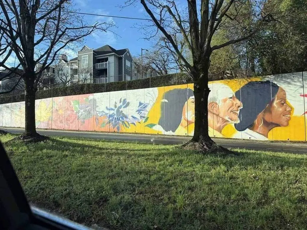 A new public-art mural of Atlanta faces along a Downtown corridor